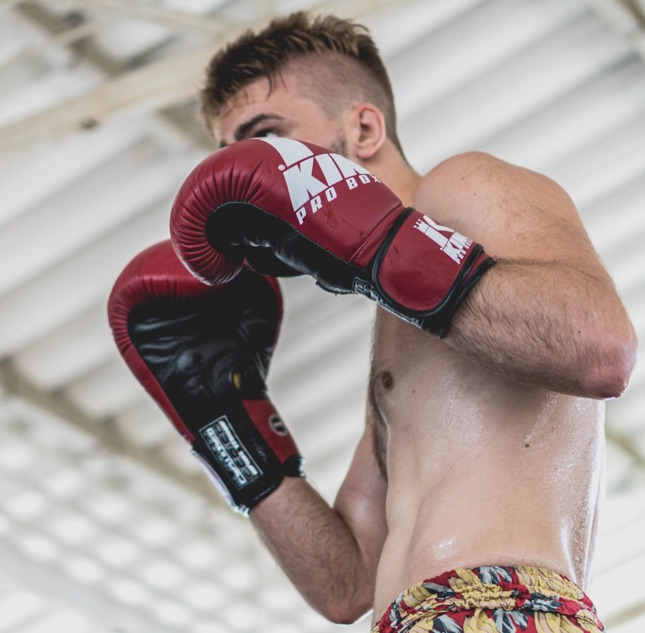 Muay Thai athlete training in red gloves